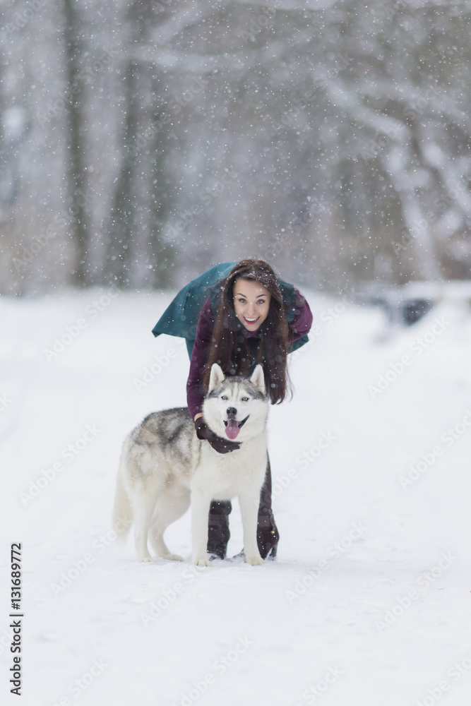 Caucasian Brunette Girl Posing With Her Husky Dog Outside in Winter Forest