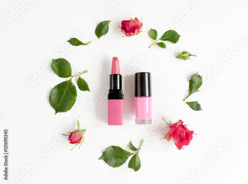 berry color decorative cosmetics with roses white background top view