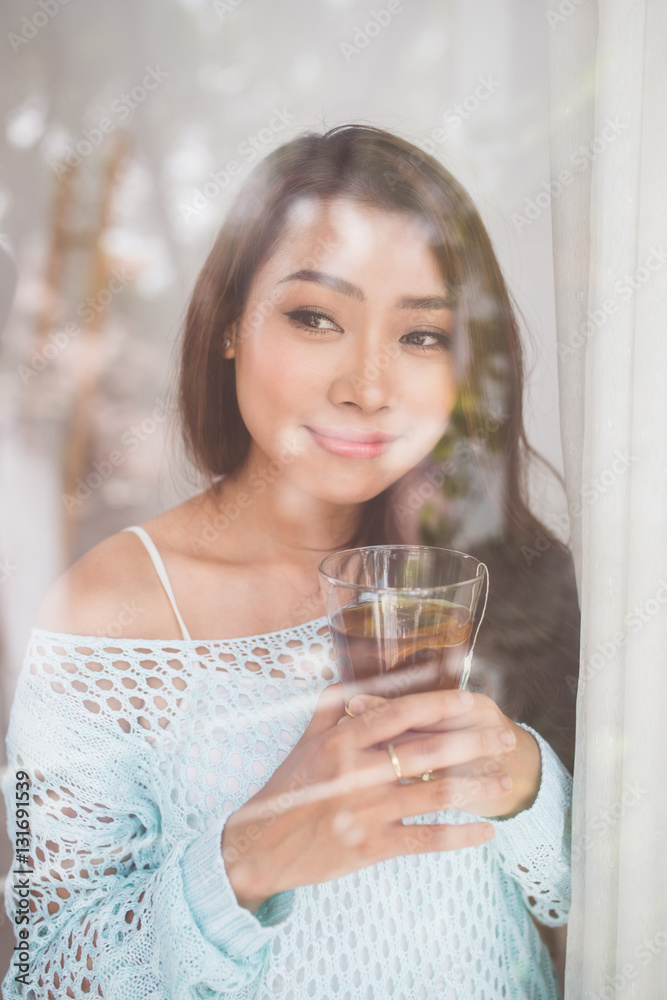 Portrait of a gorgeous young asian woman relaxing with cup of ho Portrait of a gorgeous young asian woman relaxing with cup of ho