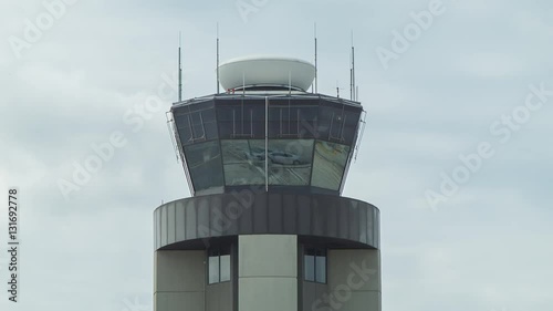 Close-up of the Air Traffic Control ATC Tower at Louis Armstrong New Orleans International Airport with Communication Antennae and Spinning Radar on a Cloudy Overcast Day in Louisiana photo