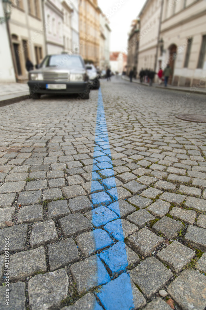 Blue parking lane on old cobblestone pavement
