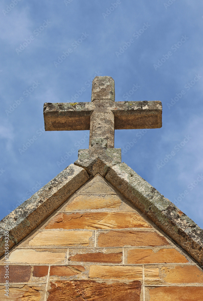 a church cross in a bright blue sky