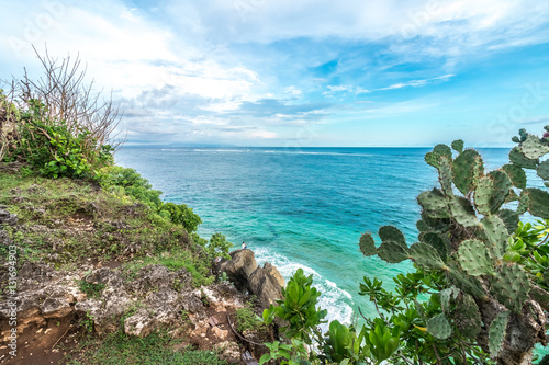 Tropical island landscape, ocean on a bacakground. Beautiful view from the cliff to the coast. Outdoor scenery, Bali island, Indonesia.