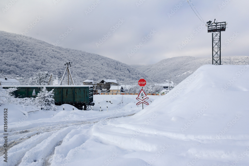 railway crossing in the village on a background of forest hills in the winter time early in the morning railway crossing in the village on a background of forest hills in the winter time early in the morning