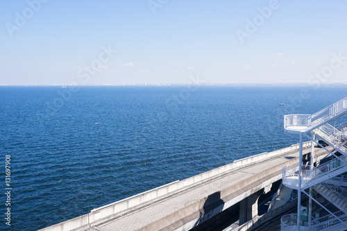 panoramic bird eye top aerial view with beautiful sea level with highway road under dramatic clear glow and fantasy blue sky in Umi Hotaru parking area island Tokyo bay aqua line, Japan © voyata