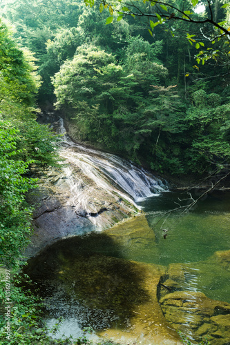 Japan travel concept - beautiful yoro keikoku valley waterfall under dramatic sun glow and morning blue sky in Chiba Prefecture  Japan