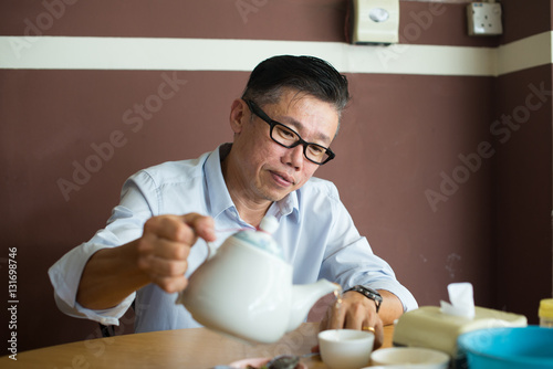matured asian male drinking tea