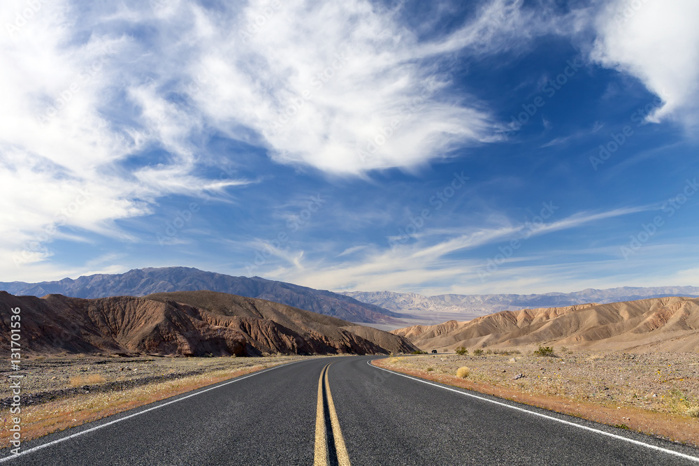 Death Valley desert roadway with blue sky.