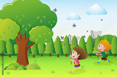 Park scene with two kids catching butterflies