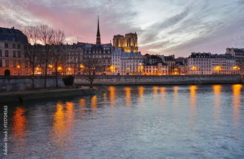 Beautiful pink sky at sunset over the Notre-Dame cathedral and the Seine River in Paris, France