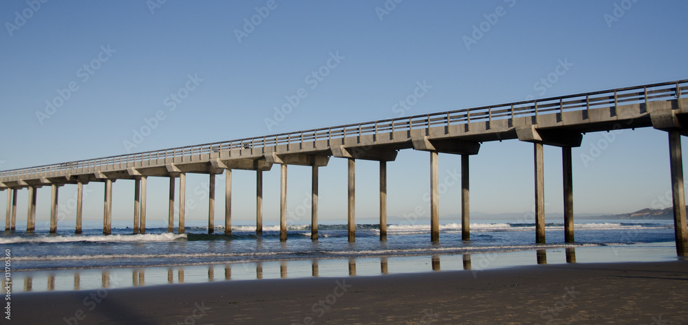 Naklejka premium Reflections in sunrise under a tall Pier at La Jolla Bay