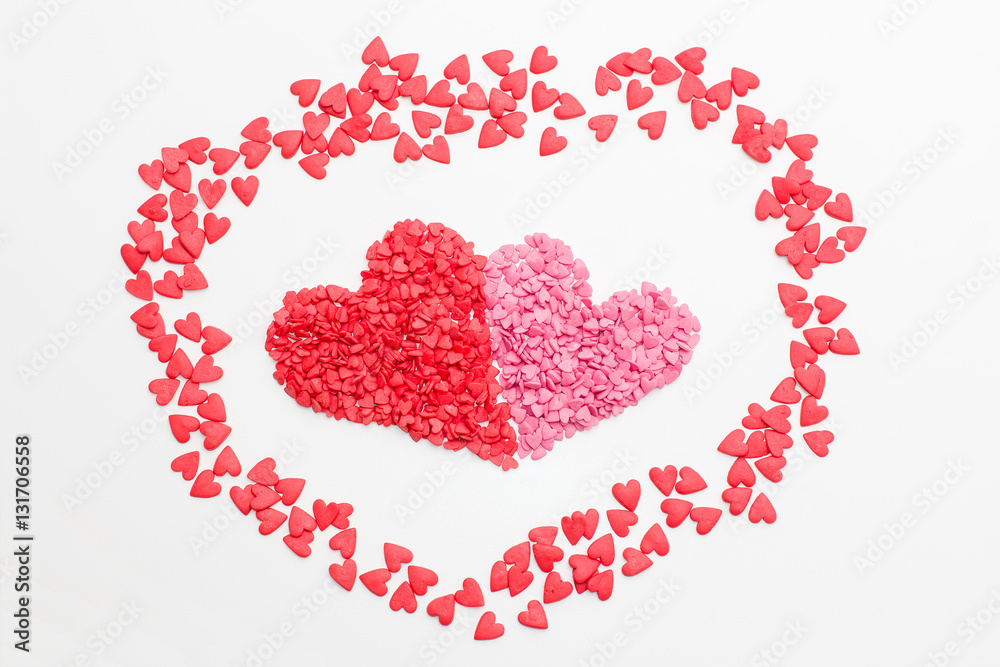 red heart next to the pink heart made of small decorative hearts on white background. festive background for Valentine's day, birthday, holiday