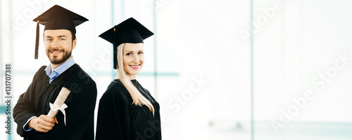 graduation - happy students wearing gown and cap. copy space photo