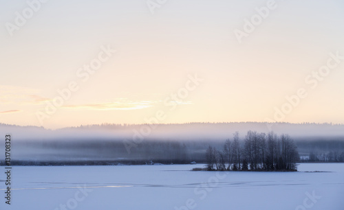 Sunrise on a winter morning. Fog is covering the landscape.