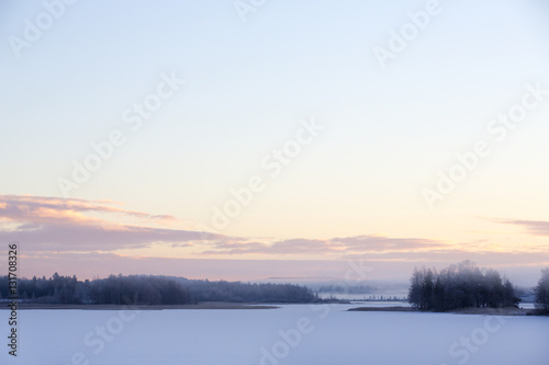 Sunrise on a winter morning. Fog is covering the landscape.