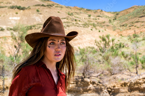 girl in a cowboy hat on a background of mountains