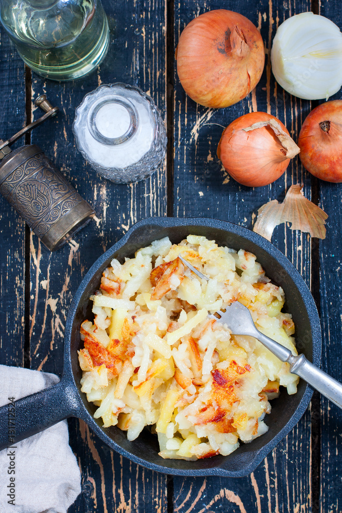 Fried potatoes with onions in castiron frying pan StockFoto Adobe Stock