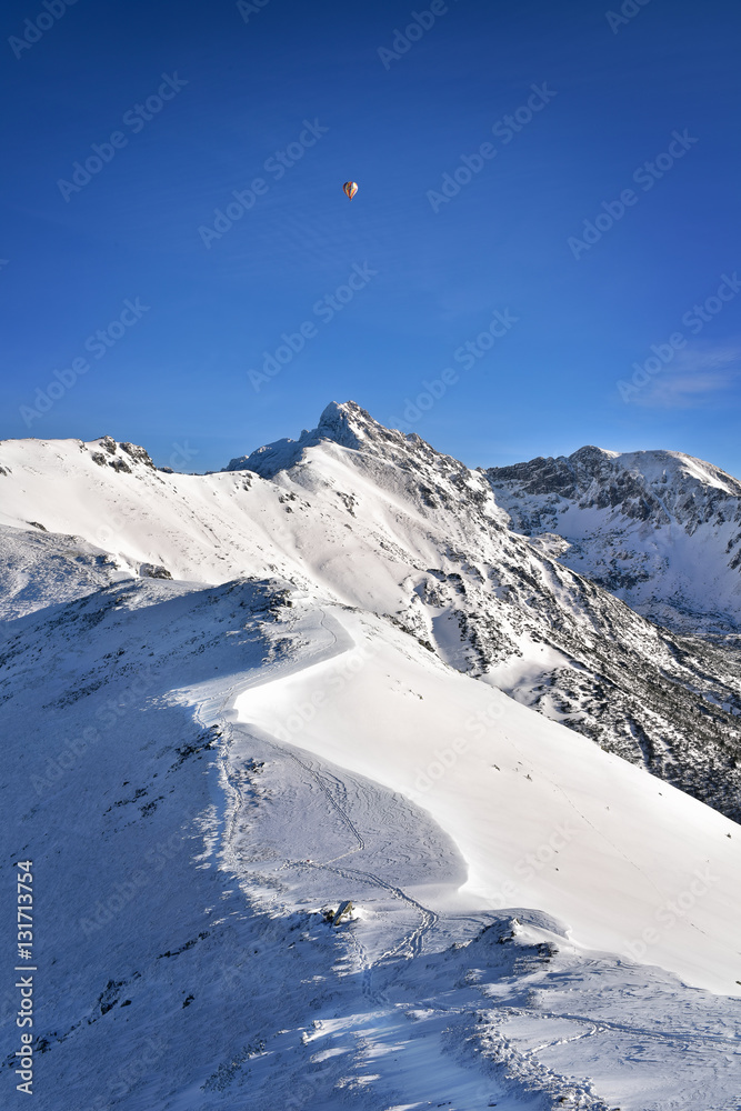 Balloon over the snowy Swinica peak. Tatra mountain