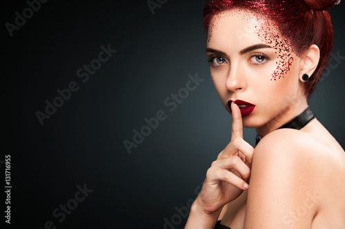 Bright beautiful readhead girl with tinsel hairstyle and art makup.