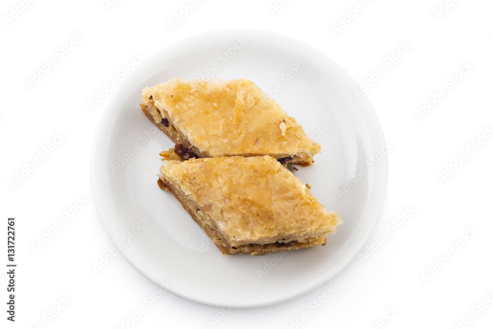 Turkish cake baklava pieces, traditional sweet, on white plate isolated on white background Turkish cake baklava pieces, traditional sweet, on white plate isolated on white background