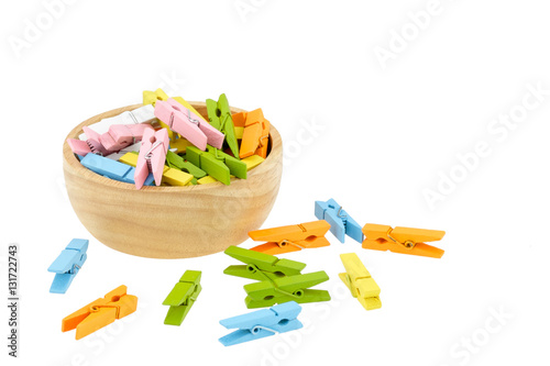 Group colorful of wooden clothespins in wooden cup isolated on white background. photo