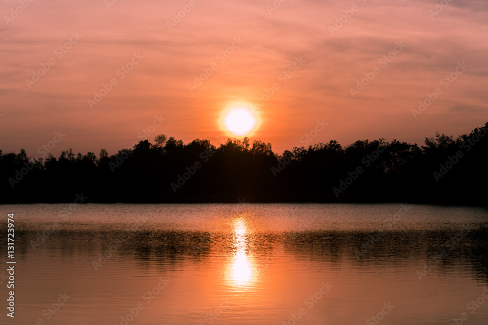 Obraz premium sunset on the river with reflex - reflection in the water surface, Sunset on the lake with trees sillouette