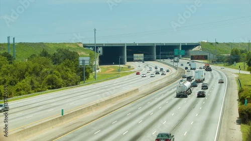 Traffic on The Perimeter or Interstate 285 adjacent to Hartsfield-Jackson Atlanta International Airport with an Airliner Landing on the Runway Overpass photo