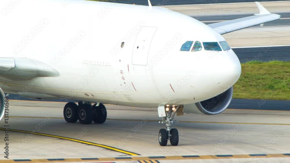 White Airbus A310 Cargo Freight Airplane Turning on an Airport Taxiway Closeup White Airbus A310 Cargo Freight Airplane Turning on an Airport Taxiway Closeup