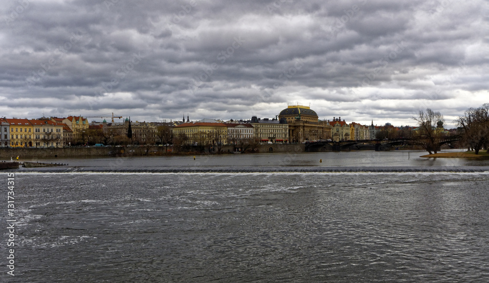 Huge expanse of the Vltava river with the city of Prague surrounding its bank