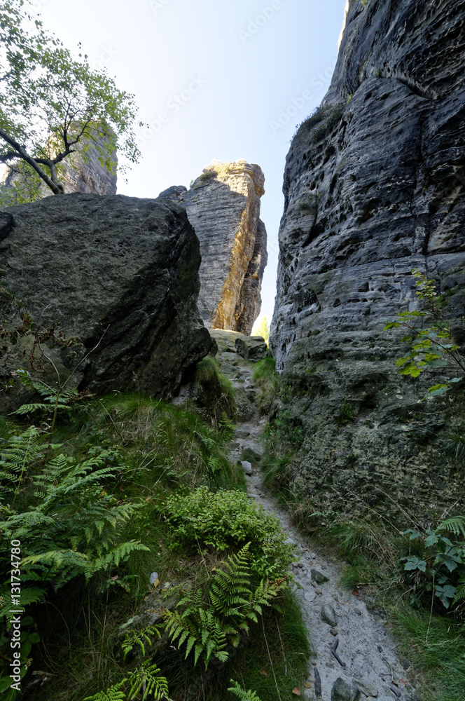 An extremely narrow path going in between tall rock formations