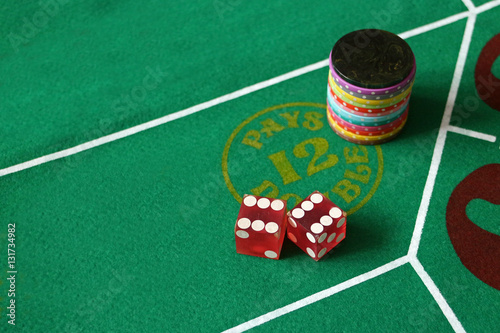 Фотография Dice craps boxcars pays double green felt with red dice many colored casino chip