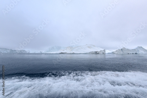 Arctic Icebergs Greenland in the arctic sea. You can easily see that iceberg is over the water surface, and below the water surface. Sometimes unbelievable that 90% of an iceberg is under water