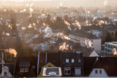 Rauchende Schornsteine über den Dächern einer Stadt