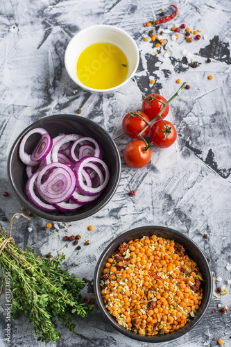 Ingredients for homemade soup with lentils, bulgur, tomatoes, peppers, herbs on a gray marble background. Top view. The concept of home seasonal food.