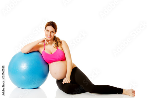 Young pregnant woman excercises with gymnastic ball