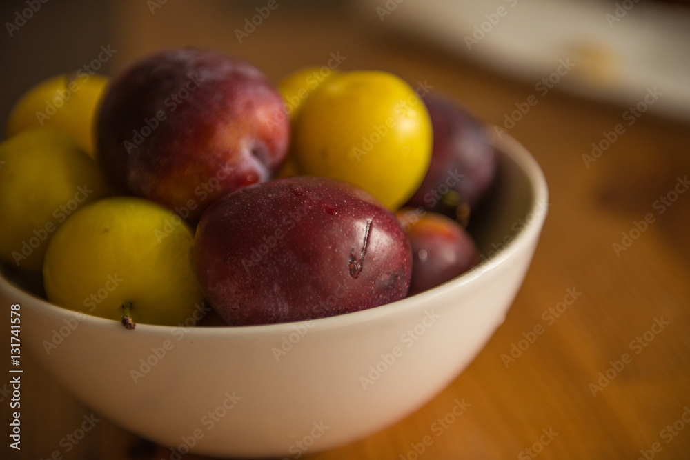 Purple and yellow plums in bowl Purple and yellow plums in bowl