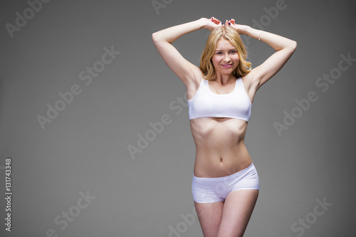 Young beautiful blonde woman in white fitness clothing © Andrey_Arkusha