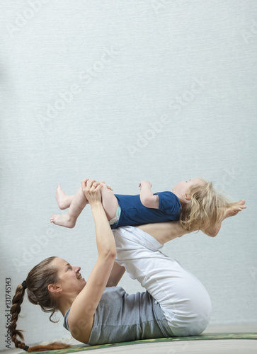Hatha yoga fitness mother with baby.