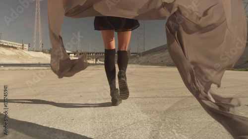 Beautiful girl with the waving fabric positing, dancing, running, walking in the LA River. Industrial area fashion videoshoot.