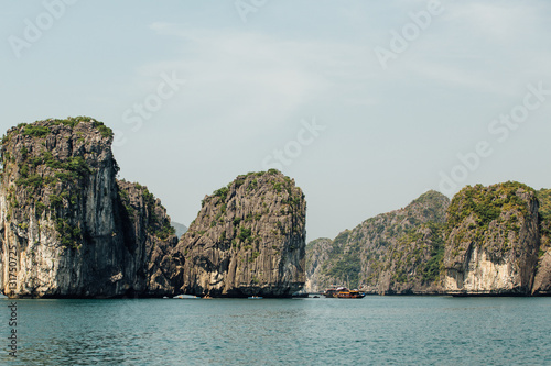 Boat goes between Scenic mountain rock face cliff in the sea wat
