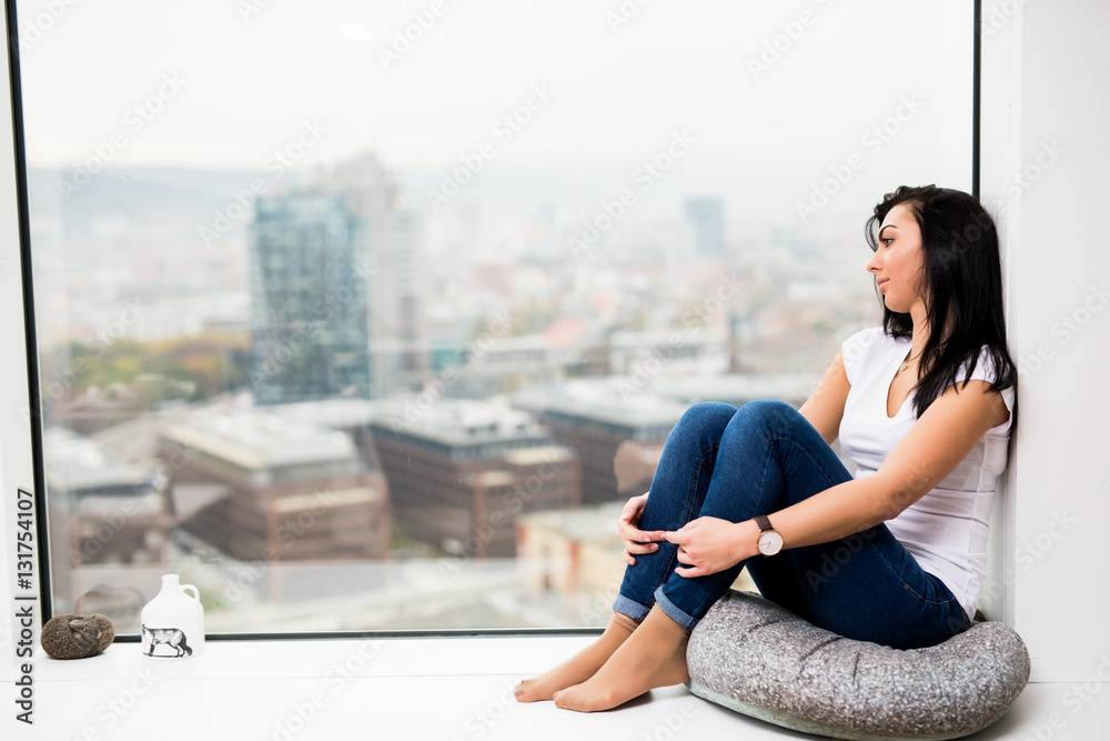 Fototapeta premium I miss you. Woman sitting on window looking out