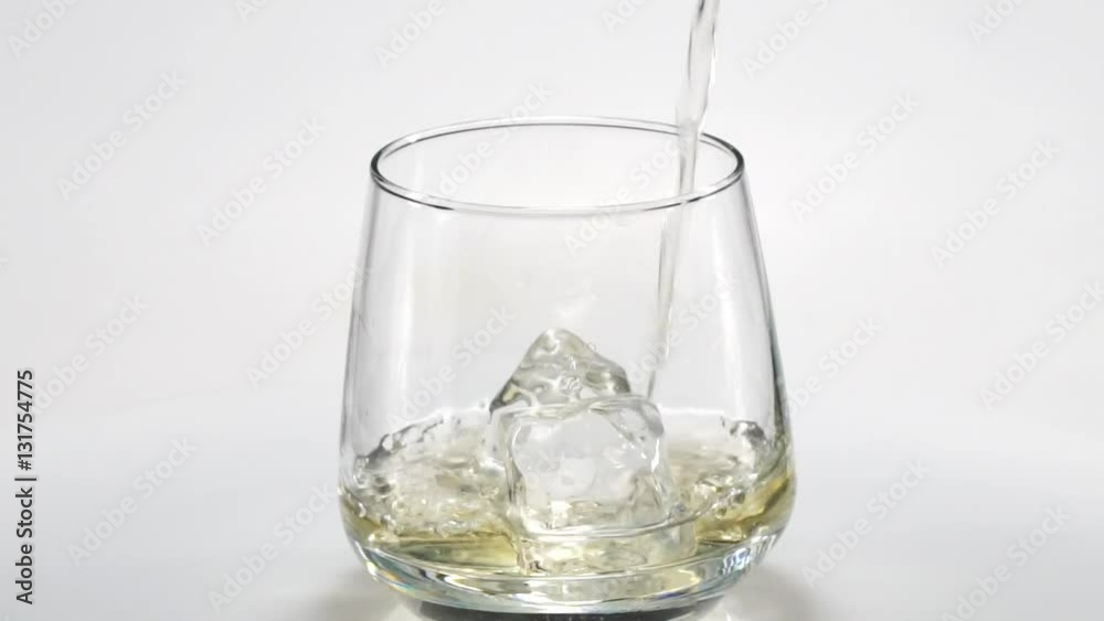 Whiskey poured into a glass with ice. Slow motion. 120fps Whiskey poured into a glass with ice. Slow motion. 120fps