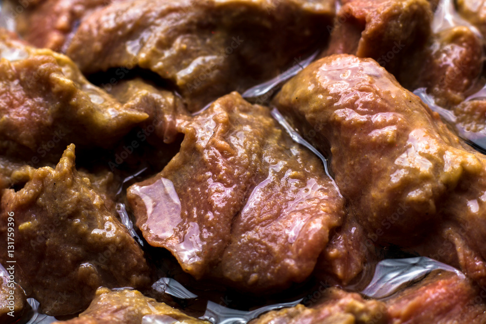 meat laid out in a skillet for frying. It is filled with oil. Close up. Preparation for cooking.
