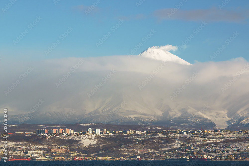Smoking Avachinsky volcano above the cloud hanging over the city of Petropavlovsk Kamchatsky on the Kamchatka Peninsula in Russia