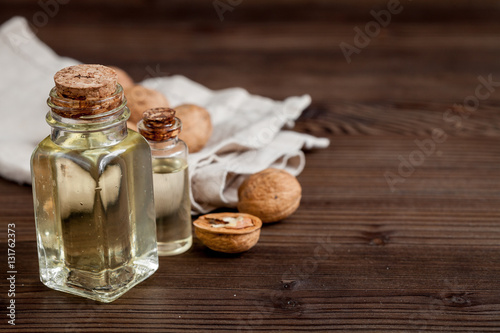 cosmetic and therapeutic walnut oil on dark wooden background