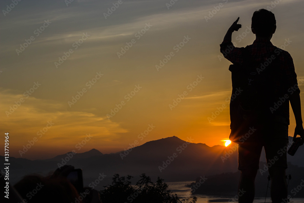 Yong man standing on sunset backdrop