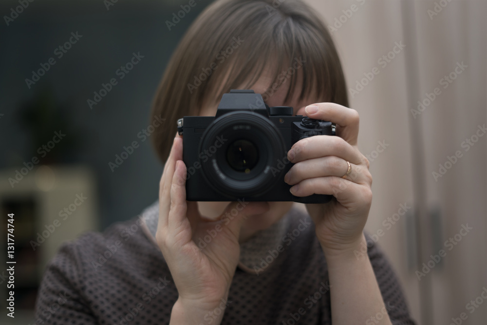 A woman holds a camera and takes pictures of herself in the mirror A woman holds a camera and takes pictures of herself in the mirror