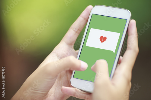 smartphone with speech bubble and broken heart