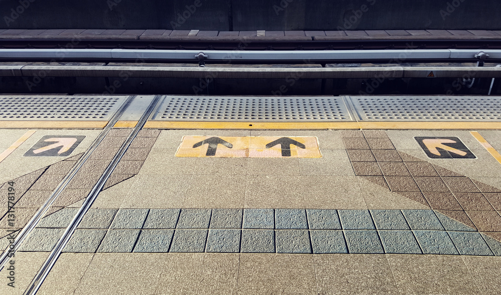 Arrow sign yellow color on floor at the sky train station