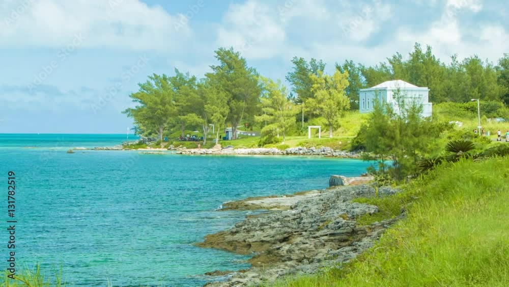 The Southern Coast Line of Bermuda with Tropical Turquoise Water, Lush Greenery and People on Segways Riding on a Distant Road